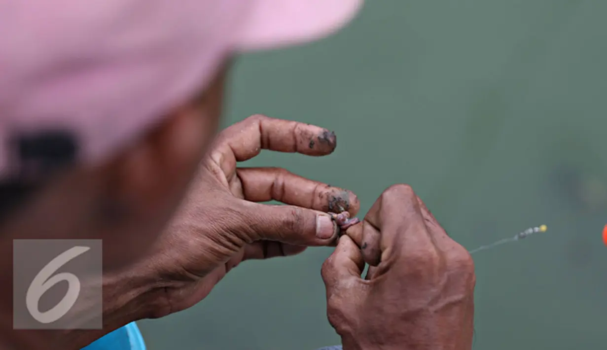 Seorang warga saat mempersiapkan umpan utk memancing ikan di Kali Tanjung Selor, Jakarta, Rabu (20/1). Dengan biaya murah Kali Tanjung Selor menjadi lokasi favorit bagi warga untuk memancing. (Liputan6.com/Immanuel Antonius)