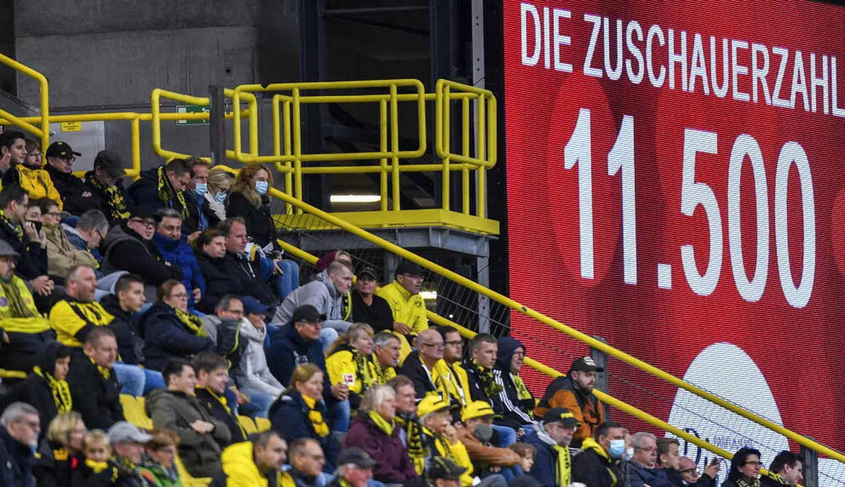 JUMLAH PENONTON DI STADION DIBATASI: Suporter saat menyaksikan pertandingan antara SC Freiburg melawan Borussia Dortmund pada laga Bundesliga, Sabtu (3/10/2020). UEFA mengizinkan penonton hadir hanya 30 persen dari kapasitas stadion. (AP Photo/Martin Meissner)