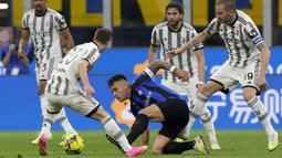 Pemain Inter Milan, Lautaro Martinez, berusaha melepaskan diri dari kawalan pemain Juventus pada laga Coppa Italia di Stadion Giuseppe Meazza Kamis (27/04/2023). Inter menang dengan skor 1-0. (AP Photo/Luca Bruno)