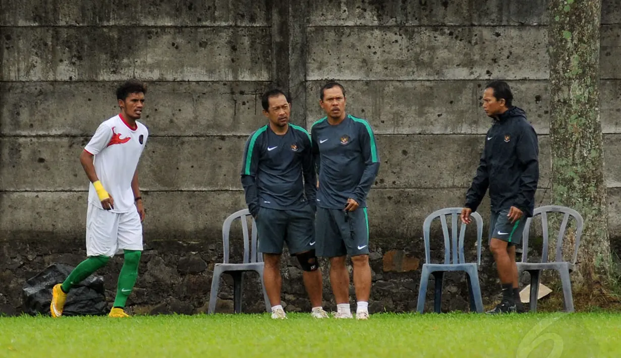 Pelatih Timnas U-23 Indonesia, Aji Santoso (kedua dari kiri) memperhatikan serius anak asuhnya berlatih tanding dengan sejumlah pemain asing di POR Sawangan, Depok, Rabu (31/12/2014). (Liputan6.com/Helmi Fithriansyah)