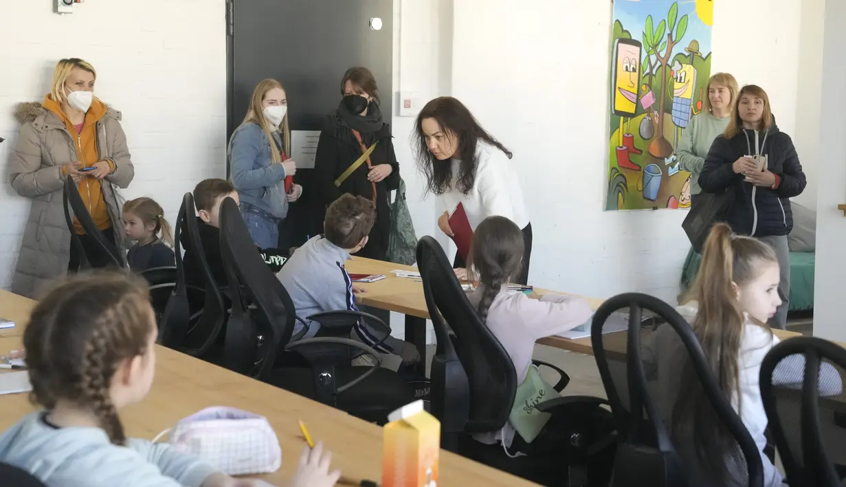 Guru Ukraina Natalia Khalil (tengah) mengajar kelas anak-anak dari Ukraina di Berlin, Jerman, Senin (21/3/2022). Empat puluh anak pengungsi Ukraina memulai hari pertama sekolah dasar di Berlin hanya beberapa minggu setelah mereka melarikan diri dari perang. (AP Photo/Markus Schreiber)