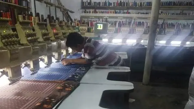Salah satu pegawai bordir Tasik tengah membetulkan mesin di salah satu sentra UMKM bordir Tasik, Kabupaten Tasikmalaya, Jawa Barat. (Liputan6.com/Jayadi Supriadin)