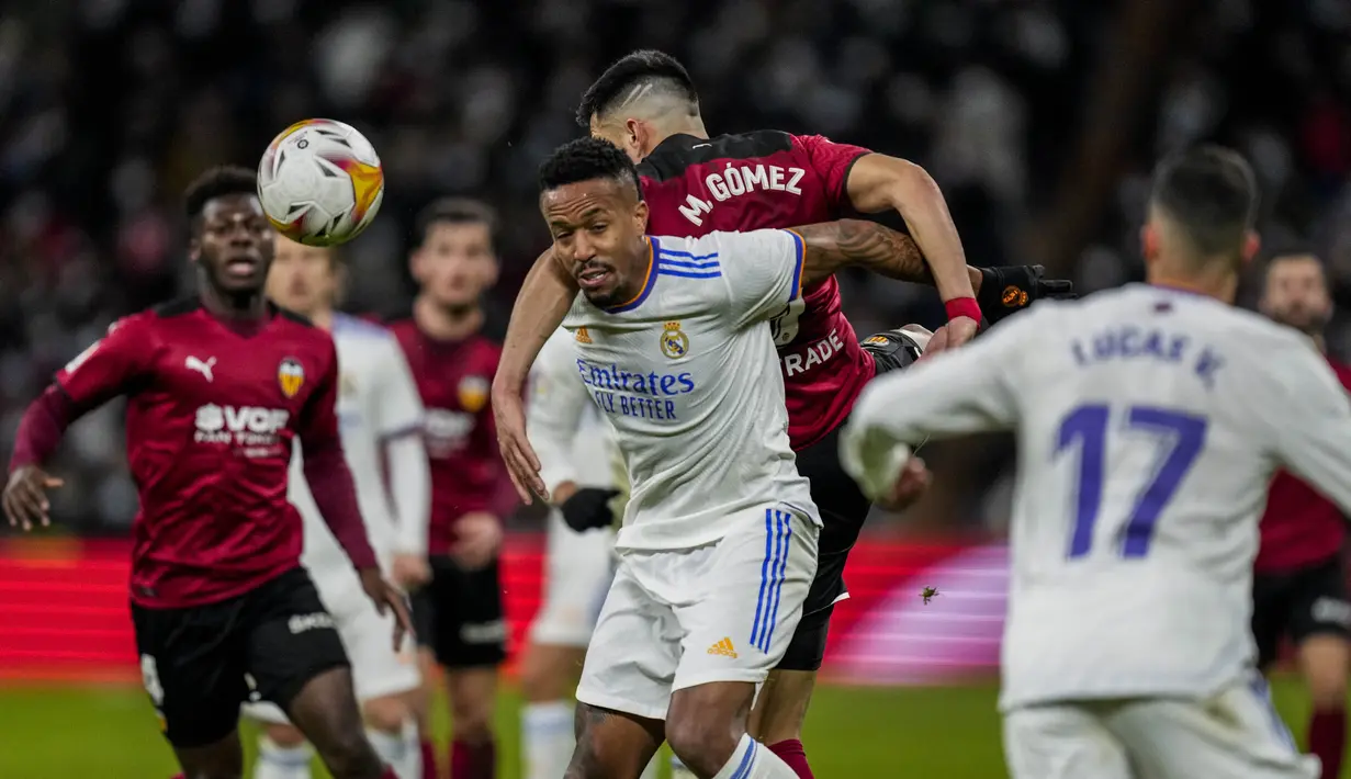 Bek Real Madrid Eder Militao berebut bola dengan penyerang Valencia Gomez pada laga pekan ke-20 La Liga Spanyol di Santiago Bernabeu Valencia, Minggu dini hari WIB (9/1/2022). Real Madrid menang meyakinkan 4-1 atas Valencia. (AP Photo/Bernat Armangue)