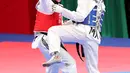 Atlet taekwondo putri Indonesia, Fitriyana Yusuf berhadapan dengan Liu Qing dari Makau pada babak 16 besar di Jakarta Convention Center (JCC), Senin (20/8). Fitriyana kalah tipis 21 - 25 pada kelas Wanita 67 kg. (Liputan6.com/Fery Pradolo)