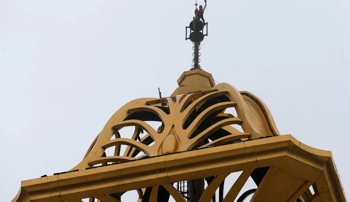 Alain Robert berhasil mencapai puncak gedung yang telah dipanjatnya setinggi 153 meter di Macaudalam promosi film The Amazing Spider-Man 2 di Macau, China, Rabu (23/4/2014) (Reuters/Bobby Yip).