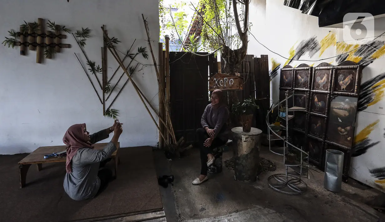 Pengunjung berfoto di Kedai Poci (KEPO), Hj Kelik, Kelapa Dua Srengseng, Jakarta Barat, Sabtu (18/9/2021). Ketua Umum Asosiasi Pengusaha Kafe dan Restoran Eddy Sutanto mengatakan, pengunjung kafe dan restoran sudah naik 20-30 persen. (Liputan6.com/Johan Tallo)