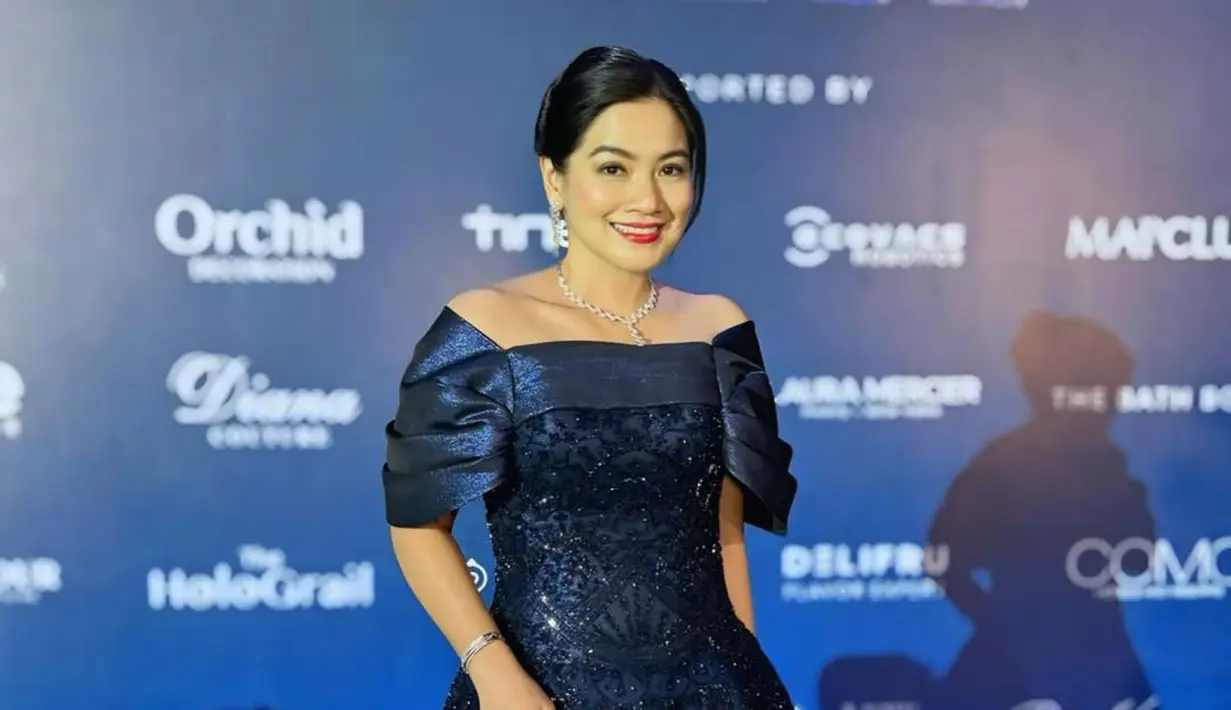 Gaun off shoulder itu menampilkan siluet H-Line dengan aksen ruffle di lengan dan full payet hitam [@titi_kamall]