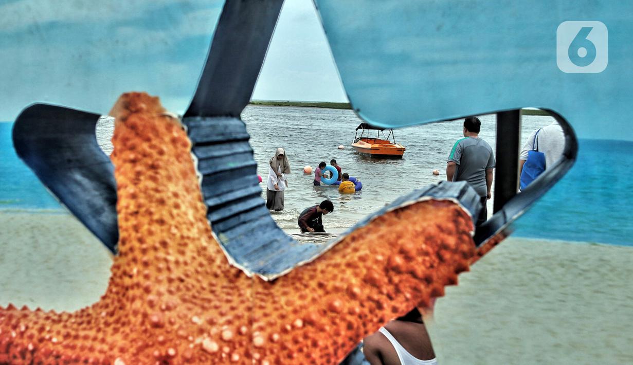 Wisatawan bermain saat mengisi libur Natal di Pantai Ancol, Jakarta, Minggu (25/12/2022). Kepala Komunikasi PT Pembangunan Jaya Ancol Ariyadi Eko Nugroho mengungkapkan per hari ini jumlah wisatawan di Taman Impian Jaya Ancol tembus 40.000, angka tersebut meningkat dua kali lipat dibanding libur hari biasa maupun Natal tahun 2021. (merdeka.com/Iqbal S. Nugroho)