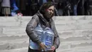 <p>Seorang perempuan membawa botol air minum dari pusat distribusi di Toretsk, Ukraina timur, pada 25 April 2022. Penduduk Toretsk tidak memiliki akses air selama lebih dari dua bulan karena perang Rusia Ukraina. (AP Photo/Evgeniy Maloletka)</p>
