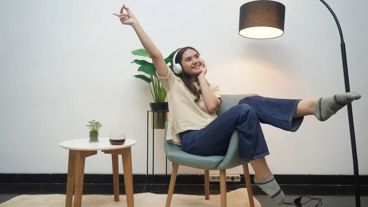 wanita november sofa headphone senyum