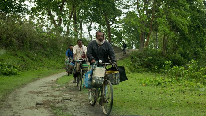 Nelayan mengendarai sepeda untuk membeli ikan di tepi sungai Brahmaputra, India (3/4). Assam sangat kaya akan sumber daya airnya. Brahmaputra adalah salah satu sungai terbesar di Asia, yang melewati wilayah China Tibet, India dan Bangladesh sebelum konvergen ke Teluk Benggala. (AP Photo/Anupam Nath)