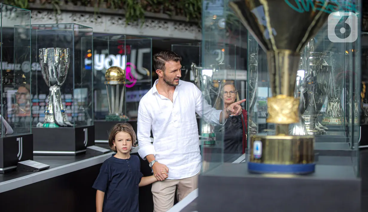 Pengunjung melihat trofi kemenangan Juventus yang dipamerkan pada Juventus Village di Lippo Mall Kemang, Jakarta, Jumat (27/1/2023). Juventus Village berlangsung pada 27-29 Januari 2023 meliputi pameran trofi pertama di Asia Tenggara sepanjang sejarah klub, koleksi sejarah Juventus, pameran tempat-tempat bersejarah di stadion dan pameran merchandise klub. (Liputan6.com/Faizal Fanani)
