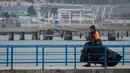 Seorang anggota Kementerian Pertahanan Rusia membawa kantong plastik menuju  dermaga tidak jauh dari kecelakaan pesawat militer Rusia Tu-154 di Laut Hitam di pinggiran Sochi, Rusia (25/12). (REUTERS/Maxim Shemetov)