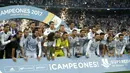Cristiano Ronaldo (kiri) berfoto bersama timnya saat meraih trofi Piala Super Spanyol 2017 bersama rekannya di Santiago Bernabeu stadium, Madrid, (16/8/2017). Real menang agregat 5-1. (AP/Francisco Seco)