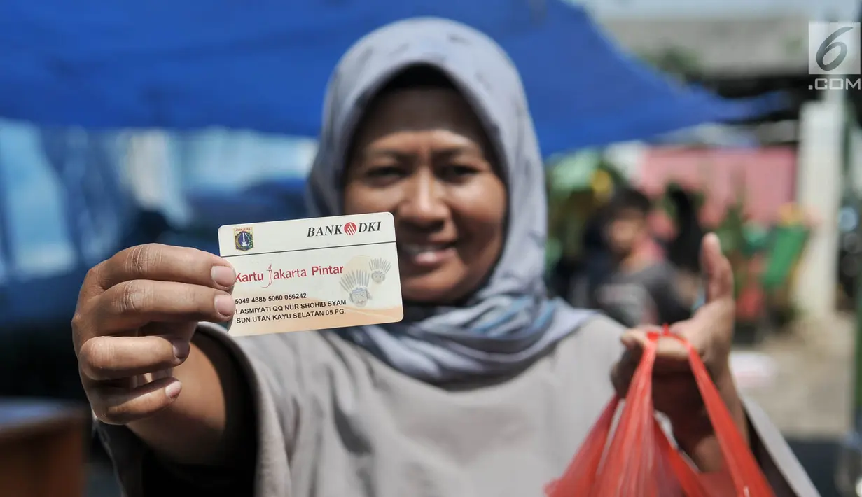 Warga menunjukkan KJP dan kebutuhan pokok yang dibeli dari Program Pangan Murah di RPTRA Utakara Beriman, Jakarta, Kamis (20/6/2019). Program tersebut juga bertujuan meningkatkan gizi warga pemegang Kartu Lansia Jakarta, PPSU, PHL, PJLP, UMP, serta penghuni Rusun Pemda. (merdeka.com/Iqbal S Nugroho)