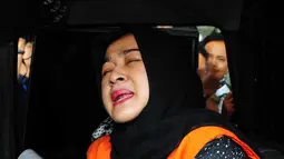 Evy Susanti saat berada di dalam mobil tahanan Usai diperiksa oleh KPK, Jakarta, Jumat (11/9/2015). Evy mengaku, dalam pemeriksaan kali ini, kondisi tubuhnya dalam keadaan kurang sehat. (Liputan6.com/Helmi Afandi)