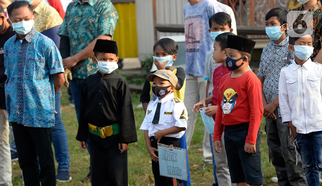 Warga Rt 06 Rw 10 mengikuti upacara HUT ke-75 Kemerdekaan RI di Kelurahan Ciater, Serpong, Tangerang Selatan, Senin (17/8/2020). Selain mengenakan baju adat, tak sedikit warga yang berpakaian seadanya untuk memperingati 17 Agustus dengan tetap menerapkan protokol Kesehatan. (merdeka.com/Dwi Narwoko)