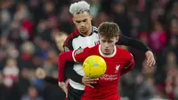 Bek Liverpool, Conor Bradley (depan) menguasai bola dibayangi bek Fulham, Antonee Robinson pada laga leg pertama babak semifinal Carabao Cup 2023/2024 di Anfield Stadium, Liverpool, Kamis (11/1/2024) dini hari WIB. (AP Photo/Jon Super)