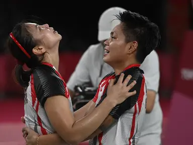 Ganda putri Indonesia Apriyani Rahayu dan Greysia Polii berselebrasi setelah menang atas pasangan China pada final badminton ganda putri Olimpiade Tokyo 2020 di Musashino Forest Sport, Senin (2/8/2021). (Alexander NEMENOV/AFP)