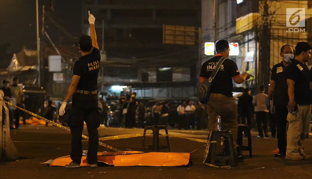 Polisi dan Puslabfor mengevakuasi potongan jenazah ketika  olah TKP ledakan di Terminal Kampung Melayu, Rabu (24/5). Jarak warga semakin menjauh di radius sekitar 150 meter lebih dari TKP. (Liputan6.com/Angga Yuniar)
