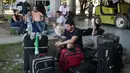 Seorang imigran Kuba memainkan ponselnya di luar gedung bea cukai di perbatasan antara Nikaragua dan Kosta Rika, Minggu (15/11). Nikaragua menutup perbatasannya dengan Kosta Rika hingga ribuan orang yang menuju Amerika terlantar. (REUTERS/Oswaldo Rivas)
