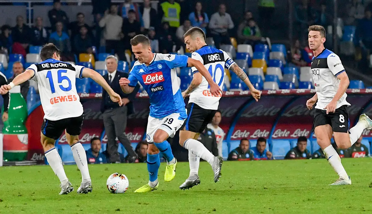 Pemain Atalanta, Marten de Roon berebut bola dengan striker Napoli, Arkadiusz Milik dalam laga pekan kesepuluh Liga Italia di Stadion San Paolo, Naples, Rabu (30/10/2019). Napoli dipaksa bermain imbang 2-2 oleh Atalanta. (Ciro Fusco/ANSA via AP)