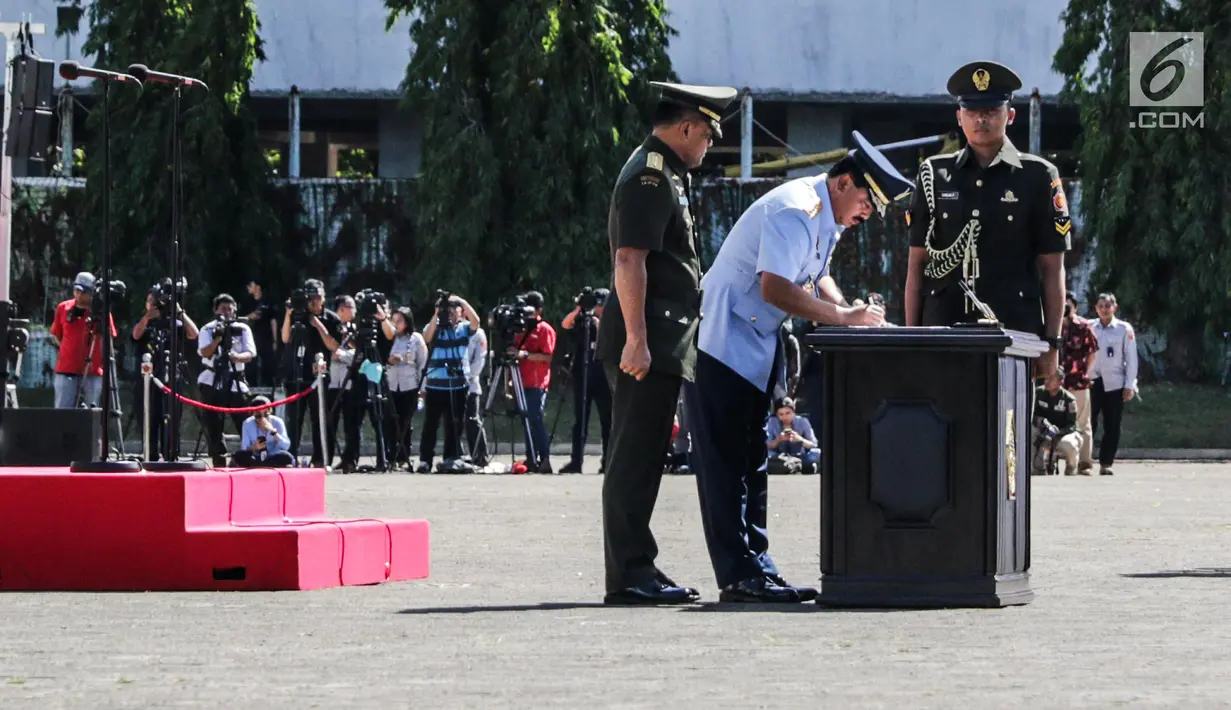 Marsekal Hadi Tjahjanto disaksikan Jenderal Gatot Nurmantyo menandatangani dokumen saat Sertijab Panglima TNI di Mabes TNI Cilangkap, Sabtu (9/12). Resmi sudah Jenderal TNI Gatot Nurmantyo menyerahkan jabatan Panglima TNI. (Liputan6.com/Faizal Fanani)