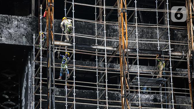 Pekerja memasang 'scaffolding' atau struktur besi untuk melakukan perbaikan Gedung Kejaksaan Agung, Jakarta, yang hangus terbakar, Rabu (7/10/2020).  Kebakaran pada 22 Agustus 2020 lalu mengakibatkan kerusakan berat pada seluruh bangunan Gedung Utama Kejaksaan Agung. (Liputan6.com/Faizal Fanani)