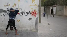 Seorang anak Palestina melakukan pemanasan saat mengikuti pelatihan tari di kamp pengungsi Al-Nusairat, Jalur Gaza tengah (5/11/2019). Pada 2012, Ahmed dan teman-temannya mendirikan sekolah tari di kamp pengungsi Nuseirat. (AP Photo/Hatem Moussa)