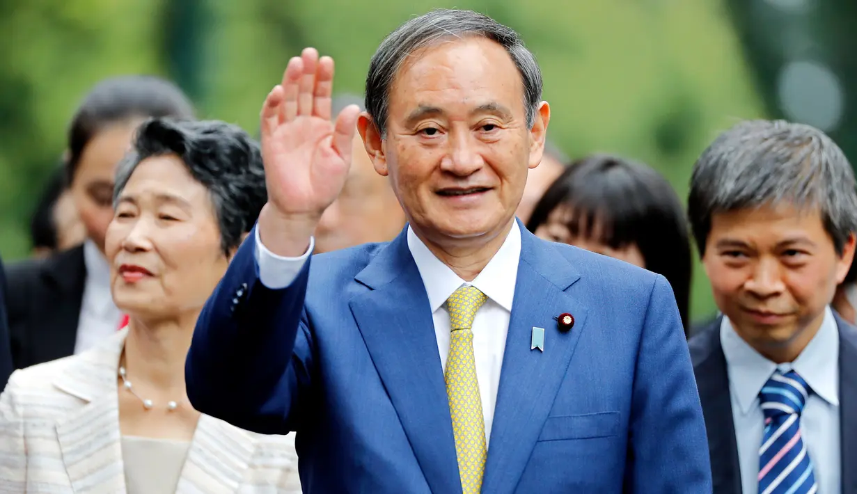 Perdana Menteri Jepang, Yoshihide Suga melambaikan tangan saat berjalan setibanya di Istana Kepresidenan, di Hanoi, Vietnam, Senin (19/10/2020). Yoshihide Suga melakukan kunjungan resmi ke Vietnam hingga 20 Oktober 2020.  (AP Photo/Minh Hoang, Pool)