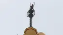  Ekspresi kebahagiaan Alain robert mengepalkan tangannya saat berada di puncak gedung di Macau, Rabu (23/4/2014) (Reuters/Bobby Yip).