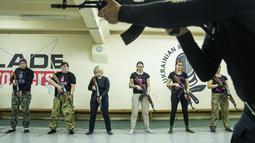 Seorang instruktur menunjukkan cara menggunakan senjata kepada sekelompok wanita selama pelatihan di Kharkiv, Ukraina (30/1/2022). Kharkiv hanya berjarak 40 kilometer (25 mil) dari puluhan ribu tentara Rusia yang berkumpul di perbatasan. (AP Photo/Evgeniy Maloletka)