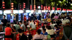 Warga menikmati makanan ringan di sebuah pasar malam di Haikou, ibu kota Provinsi Hainan, China selatan (26/3/2020). Kehidupan masyarakat di provinsi tersebut secara bertahap mulai kembali normal. (Xinhua/Guo Cheng)