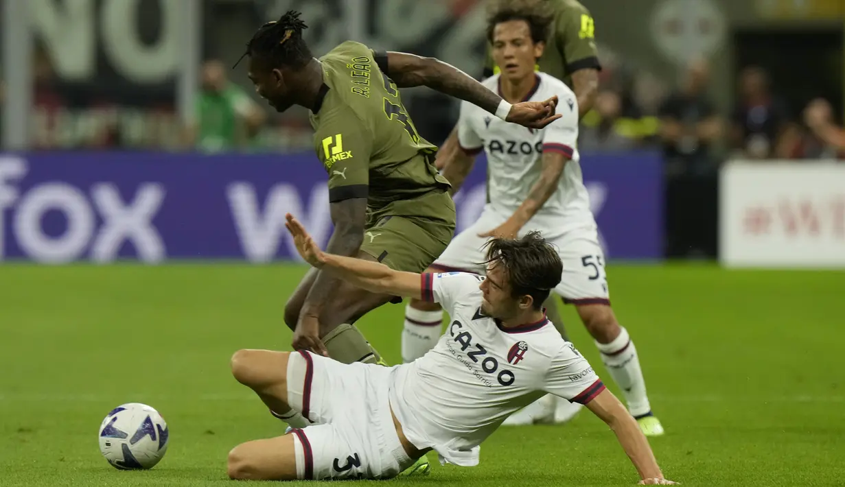 Penyerang AC Milan Rafael Leao berebut bola dengan bek Bologna Denso Kasius dalam laga giornata ke-3 Liga Italia di San Siro, Minggu dini hari WIB (28/8/2022). LAC Milan sukses mengalahkan Bologna 2-0 dengan gol-gol kemenangan skuad asuhan Stefano Pioli dibukukan Rafael Leao dan Olivier Giroud. (AP Photo/Luca Bruno)