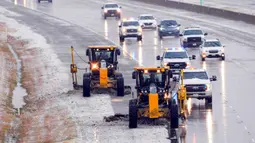 Petugas membersihkan es dari Bush Turnpike dekat Preston Road di Plano, Texas, Amerika Serikat, 1 Februari 2023. Para peramal cuaca memperkirakan hujan beku dan hujan es akan memengaruhi banyak daerah. (Smiley N. Pool/The Dallas Morning News via AP)