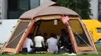 Foto 11 September 2018, karyawan perusahaan bekerja di dalam tenda kemah di halaman luar gedung kantor di Tokyo. Beberapa kantor di Jepang membebaskan pegawainya untuk bekerja di mana saja, mulai dari tenda hingga tempat karaoke. (Toshifumi KITAMURA/AFP)