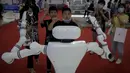 Anak-anak memberi isyarat saat mereka bermain dengan robot buatan China selama Konferensi Robot Dunia di Pusat Konferensi dan Pameran Internasional Yichuang di Beijing, Kamis (18/8/2022). (AP Photo/Andy Wong)