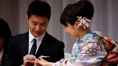 Atlet tenis meja Taiwan, Chiang Hung-chieh memasangkan cincin pernikahan ke tangan atlet tenis meja Jepang, Ai Fukuhara saat mengumumkan pernikahan kepada wartawan pada jumpa pers di Tokyo, Jepang, (21/9). (REUTERS/Toru Hanai)
