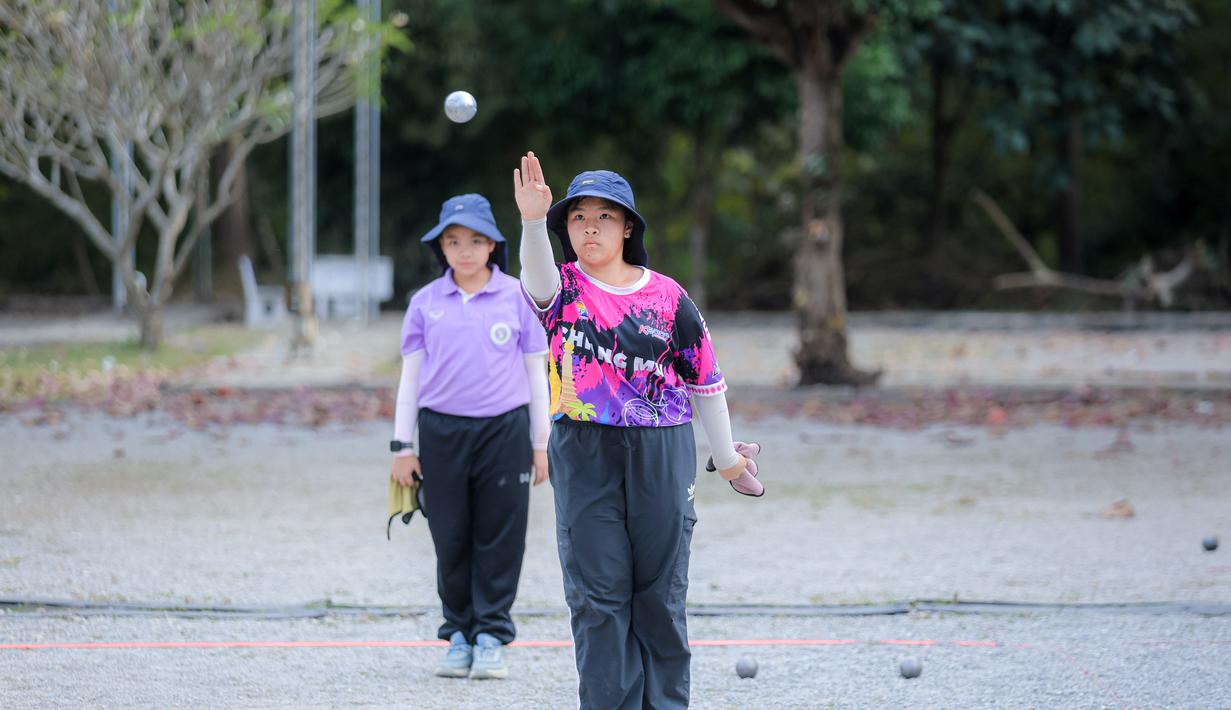 Olahraga ini memiliki sejarah panjang dan popularitas yang signifikan di negara tersebut, baik sebagai aktivitas rekreasi maupun kompetisi serius. Tampak dalam foto, atlet muda Thailand saat memainkan olahraga Petanque di Lapangan Latih Dua Kompleks 700th Anniversary of Chiang Mai Stadium, Kamis (11/12/2025). (Bola.com/Bagaskara Lazuardi)