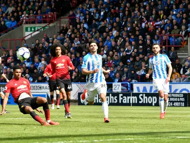 Penyerang Manchester United, Marcus Rashford terpeleset ketika berusaha melakukan tendangan ke gawang Huddersfield Town pada pekan ke-37 Liga Inggris di John Smith's Stadium, Minggu (5/5/2019). MU gagal ke Liga Champions musim depan setelah ditahan Huddersfield Town 1-1. (Anthony Devlin/PA via AP)