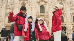 Selain naik gondola, keduanya mengunjungi berbagai tempat-tempat wisata ikonik yang biasanya ramai dikunjungi wisatawan. Salah satunya ialah Duomo di Milano di Milan. Berfoto bersama dengan jaket yang memiliki warna senada, keluarga ini pun terlihat kompak. (Liputan6.com/IG/@jud1ka)