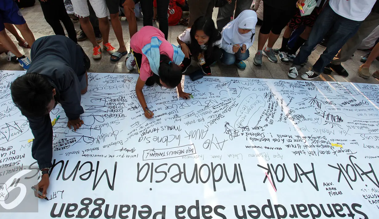 Sejumlah anak menulis di banner yang telah disediakan salah satu perusahaan alat tulis saat memperingati Hari Pelanggan Nasional di Bundaran Hotel Indonesia, Jakarta, Minggu, (6/9/2015). (Liputan6.com/Helmi Afandi) 