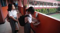 Siswa mencuci tangan saat uji coba pembelajaran tatap muka (PTM) terbatas di SMAN 1 Kota Tangerang, Banten, Senin (6/9/2021). Dinas Pendidikan Provinsi Banten uji coba PTM di SMA di Kota Tangerang secara terbatas dengan bergiliran dan menerapkan protokol kesehatan ketat. (Liputan6.com/Angga Yuniar)