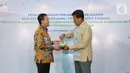 Direktur Utama BPJS Ketenagakerjaan (BPJAMSOSTEK) Anggoro Eko Cahyo (kanan) dan Direktur Utama Bank Aceh Haizir Sulaiman (kiri) memberikan cinderamata usai penandatanganan PKS di Plaza BPJAMSOSTEK Jakarta, Kamis (24/03/2022). (Liputan6.com/Fery Pradolo)
