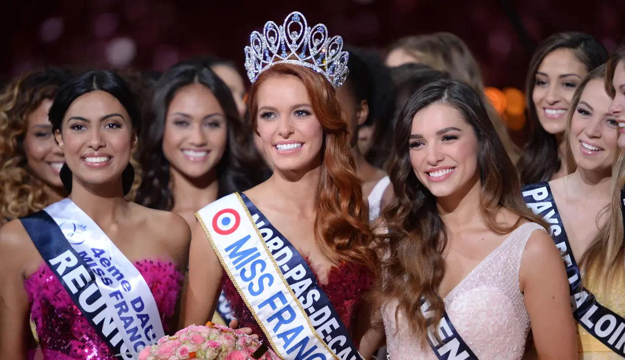 Maeva Coucke (tengah) berpose dengan kontestan lainnya usai memenangkan kontes Miss France 2018 di Chateauroux, Prancis (16/12). Maeva Coucke merupakan mahasiswi hukum di Lille University of Health and Law in Corporate Law. (AFP Photo/Guillaume Souvant)