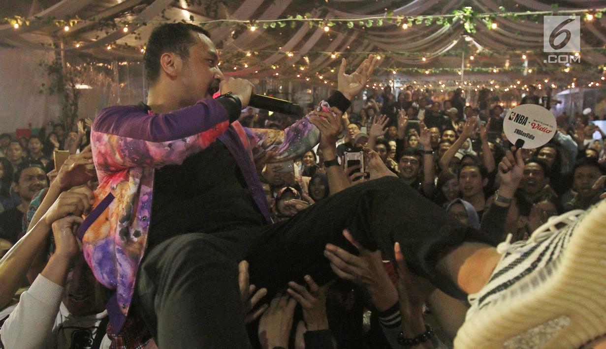 Vokalis Grup band Nidji, Giring meloncak ke arah penonton saat tampil dalam acara BRIZZI Vidio Fair 2017 di The Space Senayan City, Jakarta Pusat, Sabtu (9/12). Hampir seluruh lagu hits Nidji dibawakan Giring Cs. (Liputan6.com/Herman Zakharia)