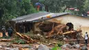 Petugas dibantu warga melakukan pencarian korban usai tanah longsor di Regent, Freetown, Sierra Leone, (14/8). Bencana ini terjadi saat penduduk tengah tidur sehingga banyak yang terjebak di dalam rumah. (AFP Photo/Saidu Bah)