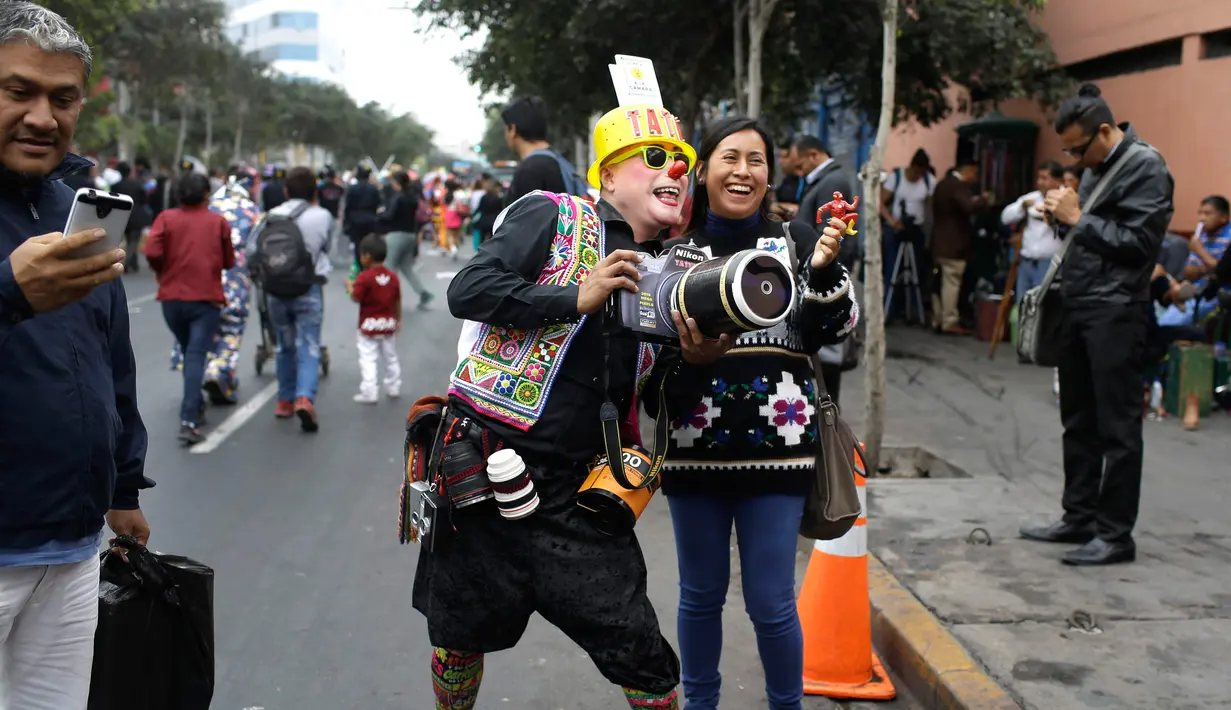 Seorang warga berfoto dengan badut ketika perayaan Hari Badut Nasional di jalanan kota Lima, Peru, Jumat (25/5). Sebagian besar badut peserta pawai merupakan badut profesional dan warga yang bersimpati. (AP Photo/Martin Mejia)