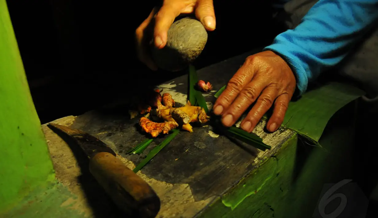 Istri Mbah Slamet Samuri sedang menyiapkan 'sesambetan' yang terdiri dari bawang merah, jahe, bangle, kunyit, kencur dan dringo, Senin (05/05/14). (Liputan6.com/Andrian M Tunay)