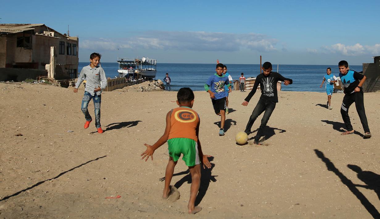 Sejumlah anak Palestina bermain sepak bola di kawasan Gaza, Jumat (3/11/2017). Sepak bola tidak hanya menjadi olahraga favorit, tapi juga sebagai salah satu cara bagi warga untuk mengurangi ketegangan akibat peperangan. (AFP/Mohammed Abed)